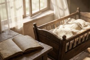 Колыбель и старинная книга с именами у окна
